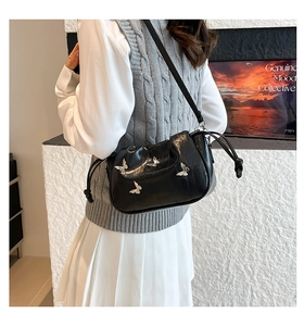 Detail view of black ruched cloud bag featuring silver butterfly charms and drawstring
