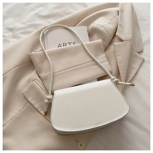 Detailed view of a white PU leather saddle bag with knot strap and gold metal hardware