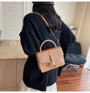 Détail du sac bandoulière kaki avec rabat texturé tressé et fermoir métallique chic