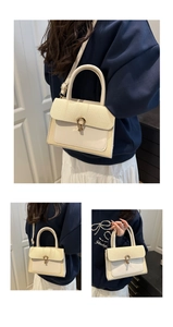 Detail of elegant beige woven contrast bag featuring golden U-shaped horsebit metal buckle