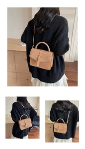 Détails du sac bandoulière marron avec rabat en texture tressée et boucle métallique