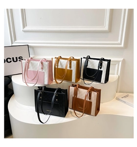 Collection of color-block tote bags in five colors displayed on white pedestals