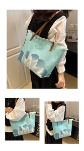 Detail of blue floral canvas tote bag featuring fringe edges and brown leather handles