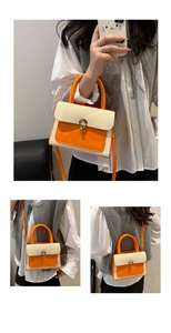 Detail of woven fabric texture and orange leather trim on a stylish square handbag