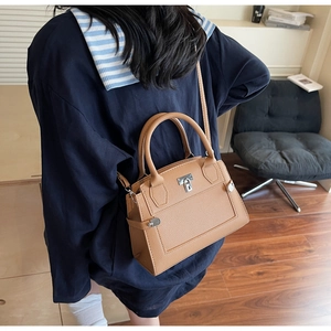 Braune Handtasche aus Leder mit Litschimaserung, silbernem Drehverschluss und Schultergurt