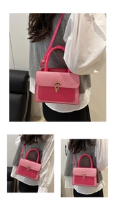 Detail of a bright pink contrast small square bag showing gold lock and stitching
