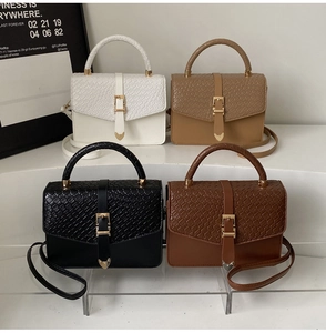 Détails rapprochés de la texture crocodile et des boucles dorées des sacs à main chics