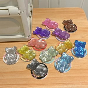 Detail of colorful water-ripple bear phone grips in various jelly colors on wooden table