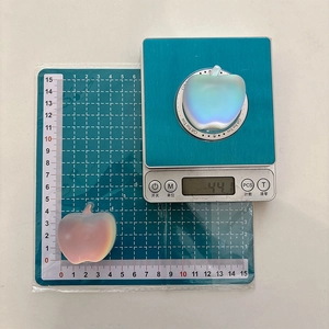 Macro shot of 44.1g iridescent apple phone grip on scale with dimensions shown