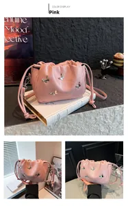 Detail of pink drawstring shoulder bag with silver butterfly rivets and pleated texture
