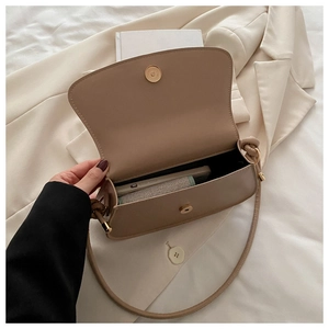 Detail showing internal capacity of the beige bow shoulder bag with magnetic gold clasp