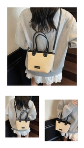 Détail du sac seau en paille avec poignées en cuir noir et texture tissée pour l'été