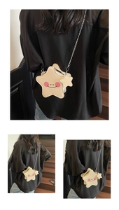 Detail of star shaped crossbody bag with smiling face and metallic chain strap