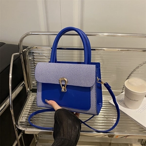 Chic color-block handbag in Klein Blue and blue-white stripes with gold metal buckle