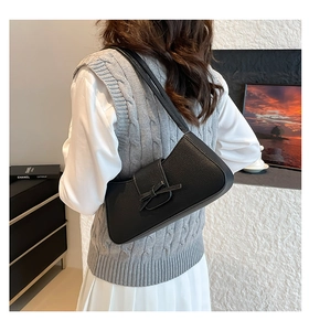 Close-up of black leather underarm bag featuring a stylish bow and litchi texture