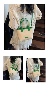 Détail du sac seau bicolore tissé avec finitions en cuir vert et logo métallique