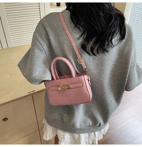 Detailed back view of pink crocodile textured mini handbag with adjustable crossbody strap