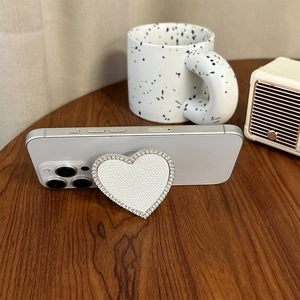 Detail of white heart-shaped phone socket with lychee leather and sparkling rhinestones