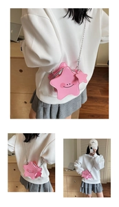 Detail of star-shaped bright pink crossbody bag with smile face and silver chain strap