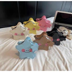 Mini star-shaped crossbody bags in six colors arranged on a bed with lifestyle props