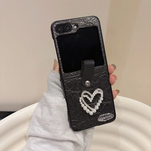 Close-up of heart pearls and lychee pattern leather on black folding phone case