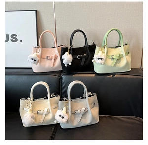 Detail of multi-color woven bucket bags with buckle accents and plush charms