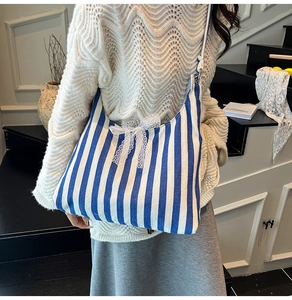 Detailaufnahme der blau-weiß gestreiften Canvas-Tasche mit dekorativer weißer Spitzenschleife