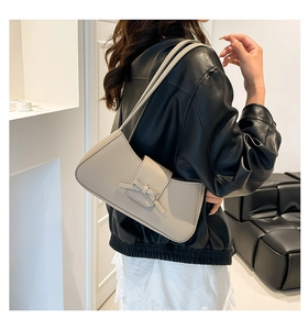 Model wearing cream bow shoulder bag in lychee texture faux leather finish