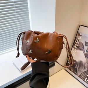 Brown ruched cloud bag with silver butterfly chains and a polished glossy finish