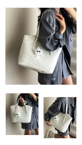 Detail of white embossed tote bag featuring fashion patterns and plush pendant accessory