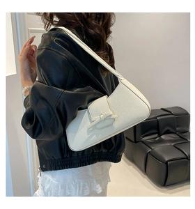 Close-up of white lychee pattern leather shoulder bag with decorative front knot detail