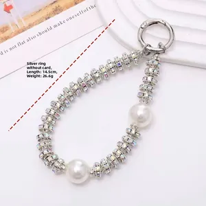 Detail of pearl phone strap with rhinestone rings and silver spring clasp hook