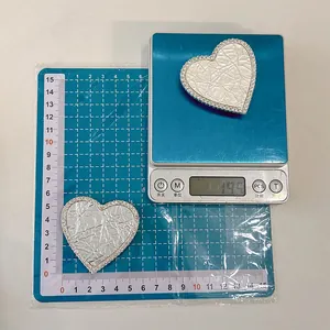 Macro shot of heart phone grip featuring white leather texture and sparkling rhinestones