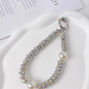 Detail of luxury pearl and rhinestone beaded phone strap with silver spring metal clasp