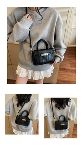 Detail of black crocodile texture mini bag with gold lock and adjustable shoulder strap