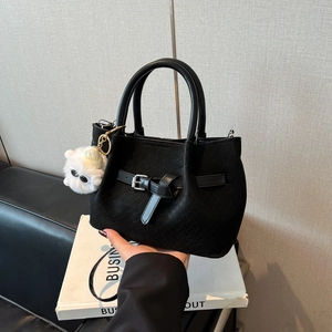 Black woven leather bucket bag with metallic buckle and cute white plush monster charm