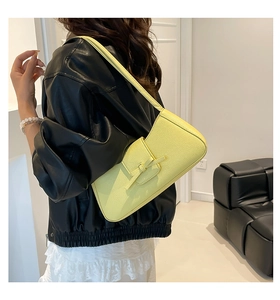 Detalle del bolso de hombro en cuero granulado amarillo claro con hebilla minimalista
