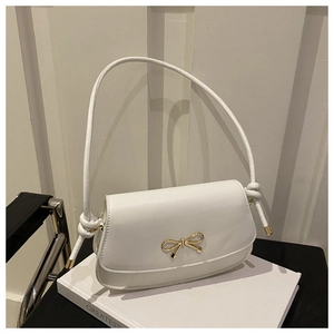 Detailed view of the gold bow metal clasp on a premium white leather crossbody handbag