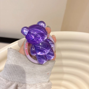 Detail of purple translucent resin bear phone holder with red Good Luck text on the base