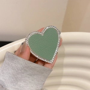 Macro detail of heart phone socket featuring sage green leather and sparkling rhinestones