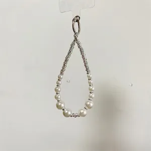 Macro shot of faux pearl lanyard with rhinestone spacers and silver metal ring connector