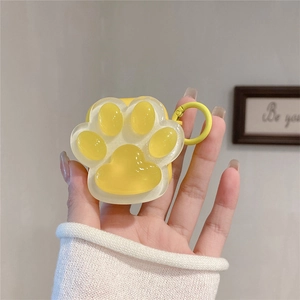 Detail of yellow silicone AirPods case featuring a 3D cat paw design and metal carabiner