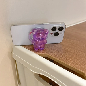 Close-up of a translucent purple bear-shaped phone grip on a white smartphone