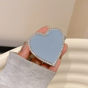 Detail of blue leather heart phone grip with silver rhinestones held by a hand