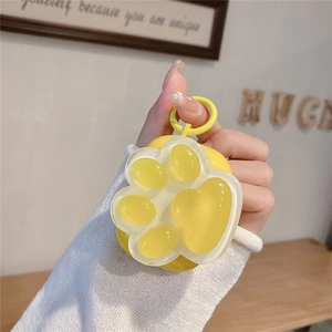 Close-up of cute yellow silicone cat paw case for AirPods with a 3D transparent soft pad