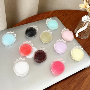Colorful strawberry shaped phone grips set on laptop for cute aesthetic desk accessory