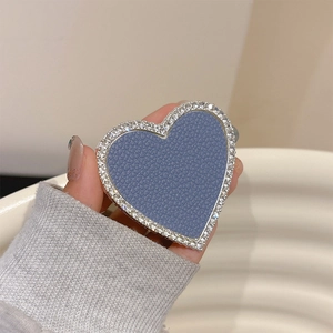 Blue lychee leather heart phone grip with sparkling rhinestone edge shown in hand