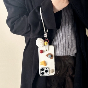 White iPhone case with colorful 3D shapes, leather strap, and plush ball pendant