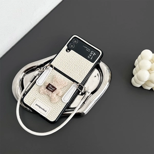Detail view of woven phone case with plush bear and hand strap for Samsung Z Flip