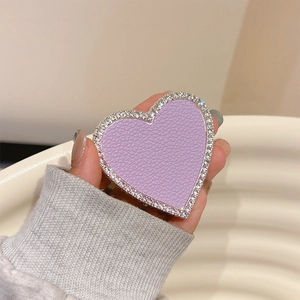 Close-up of heart-shaped phone grip with purple pebble leather and rhinestone edge